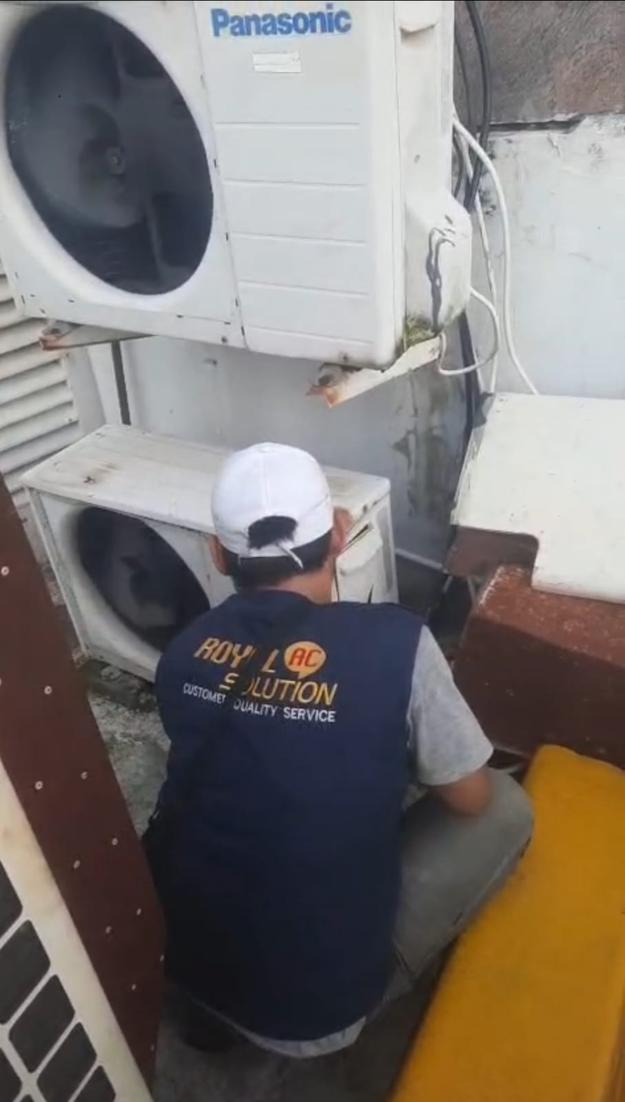 Teknisi AC Royal AC Solution Makassar sedang melakukan service AC di rumah pelanggan